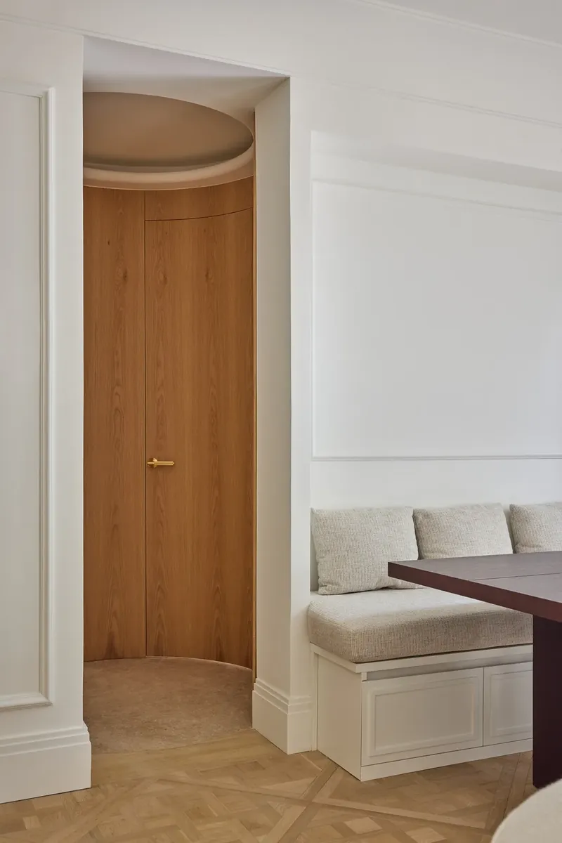 Puerta curva de roble enrasada con la pared