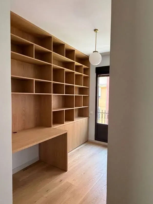 Estantería y mesa de trabajo de roble junto a la ventana