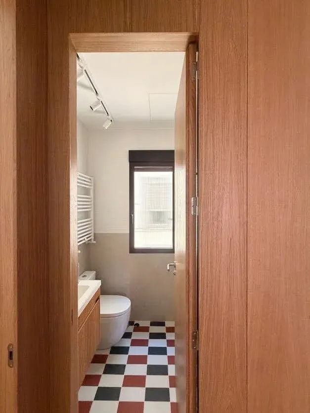 Puerta y revestimiento de roble en el baño