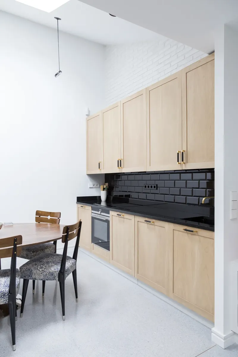 Cocina de roble con frente de azulejo negro